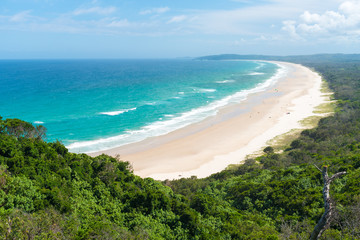 View over Tallow Beach with turquoise waters in Arakwai National Park at Byron Bay, NSW, Australia.