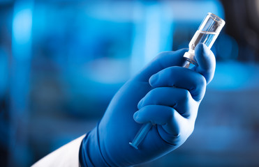 Doctor hand holds syringe and vaccine