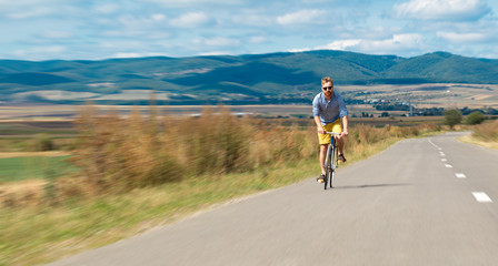 Obraz premium Natural view with cyclist going somewhere with stylish bike