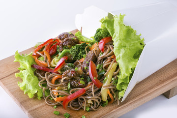 Opened box  with beef and vegetables on wooden board
