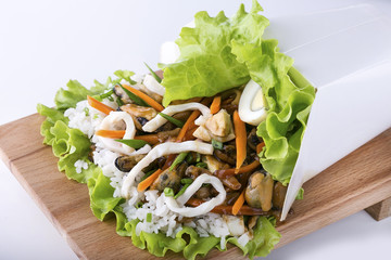Opened box of rice with seafood and vegetables