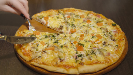 Juicy cheese pizza on a round wooden tray
