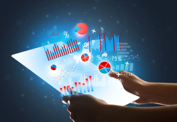 Young female hand holding a tablet with red and blue charts