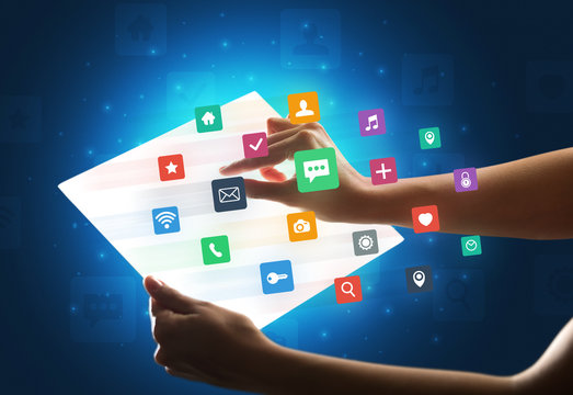 Young female hand holding a tablet with colorful mixed media icons