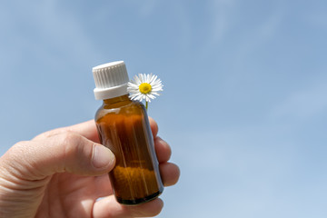 Flasche mit Globuli in der Hand 