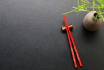 Red chopsticks on black table background Top view