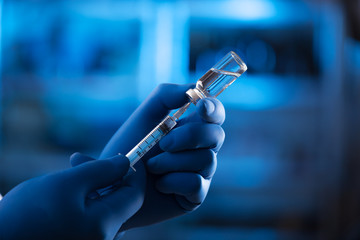 Medical hands holds syringe and vaccine