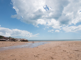 blue cloudy sky over tropical beach, creek in foreground