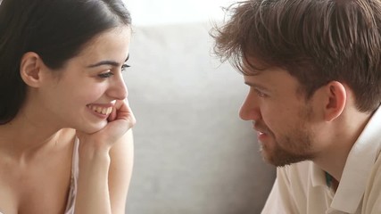 Young man making marriage proposal to surprised woman with ring in red gift box sitting on sofa, amazed happy woman agree to marry saying yes, hugging kissing future husband, couple getting engaged