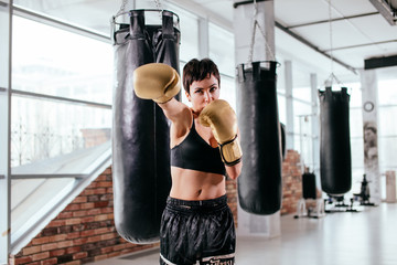 manful sportswoman is throwing puches with boxing gloves in competition. hard blow. start fighting © alfa27