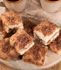 Pile of sliced cinnamon swirl crumb cake on a wooden platter