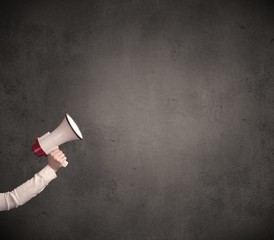 Caucasian arm holding megaphone with plain grunge background