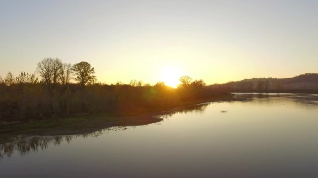 Overgrown broad river sunset sky reflection on water - aerial view