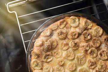 Cake with bananas on a glass plate in the oven