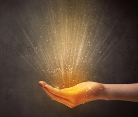 Yellow ray of light coming from a young hand 