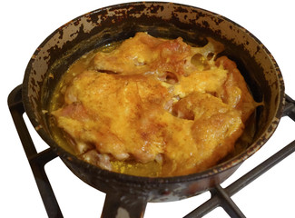 Мясо курицы под майонезом в чугунной сковороде, запечённая в духовке газовой плиты и изолированная на белом фоне