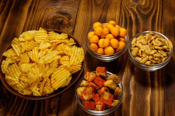 Mix of snacks for beer on wooden table