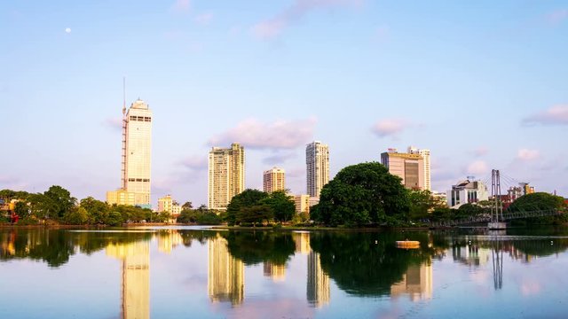 Sri Lanka. View of Beira Lake in Colombo, Sri Lanka with buddhist temple and modern buildings at sunrise. Morning time-lapse. Clear sky with moon