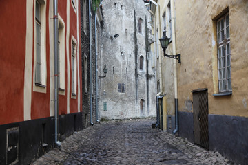 wąska brukowana uliczka między kamienicami na starym mieście - obrazy, fototapety, plakaty