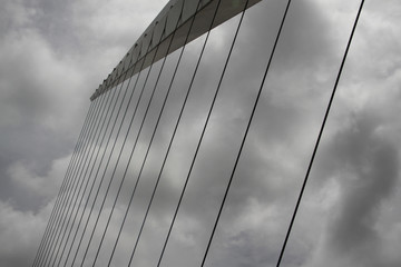 Panele Szklane  nowoczesny most o konstrukcji linowej w buenos aires na tle dramatycznego zachmurzonego nieba