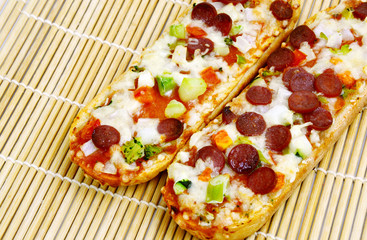 Pizza Baguette with Salami and mixed vegetable on bamboo mat
