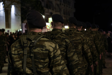 Fototapeta na wymiar Greek Army soldiers with black berets in combat uniforms. Selective focus silhouette of Hellenic Armed forces males wearing Combat Uniforms in a Camouflage Pattern.