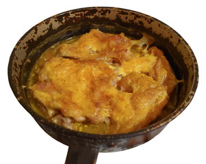 Запечённое мясо курицы под майонезом в чугунной сковороде, изолированной на белом фоне