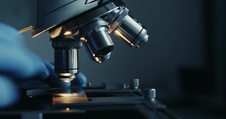 Scientist hands with microscope close-up shot in the laboratory - Powered by Adobe
