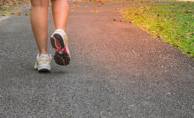 Sport girl in sporty outfit running at the lane in the park.