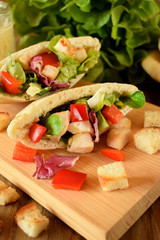 Caesar salad in pita bread on a wooden board
