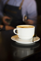 The white Cup of black espresso coffee at the bar counter in cafe