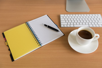 Office working wood desk with All in one Computer, note book, pen and coffee