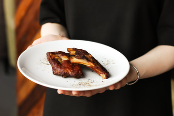 Spicy smoked beef baked pork chops ribs with spices and pepper snack to beer in white plate in...