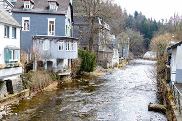 Fototapeta na wymiar Fachwerkhäuser nahe eines kleinen Flusses in der Innenstadt von Monschau in der Eifel