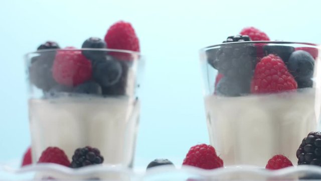 a sort of healthy breakfast with yougurt and berries in studio minimalist clip on blue background
