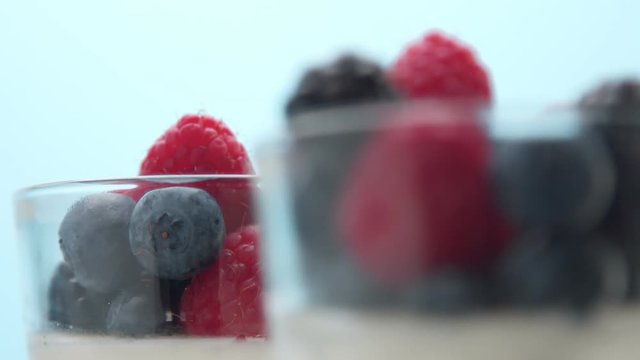 closeup of berries decoration of dessert in transparent glass full of panna cotta or greek yogurt