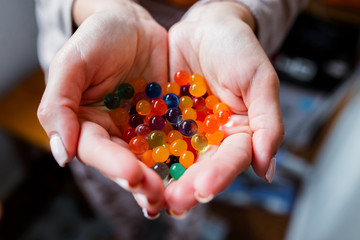 Mother stretches three colored massage balls for the children's hands development to her baby