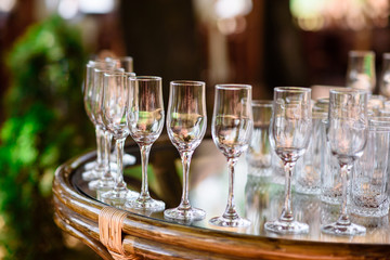 Empty wine glasses with bottle on wooden table against blurred background