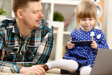 Cute little girl on floor carpet with dad