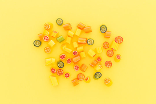Assortment of colorful sweet handmade candy pieces arranged on yellow paper