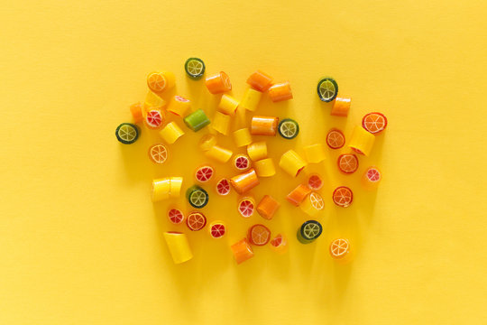 Assortment of colorful sweet handmade candy pieces arranged on yellow paper