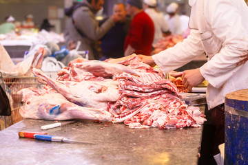 Meat seller in the market, a lot of different meat.