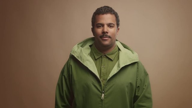 mixed race black man on beige background in studio portrait Colorfull clothes lineal dolly zoom