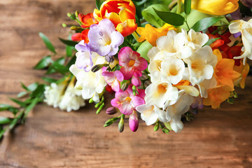 Beautiful bouquet of freesia flowers on table, closeup
