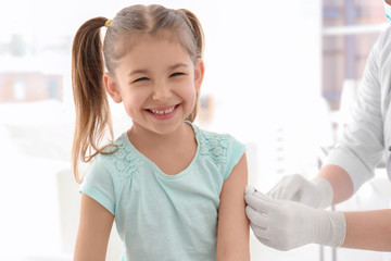 Doctor vaccinating little girl in hospital