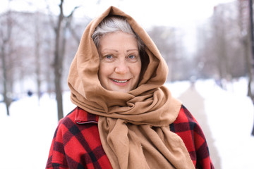 Senior woman in warm clothes outdoors. Winter vacation