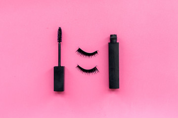 Obraz premium Basic products for eyelashes makeup. Mascara and false eyelashes on pink background top view copy space