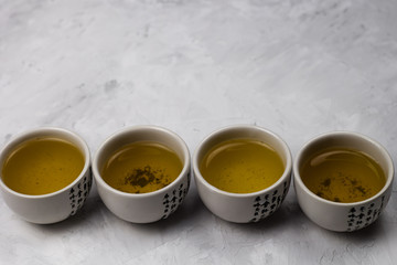 green tea bowls with hieroglyph row concrete background