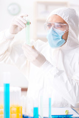 Young chemist student working in lab on chemicals