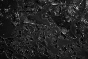 Monochrome background of ice fragments floating in the mud